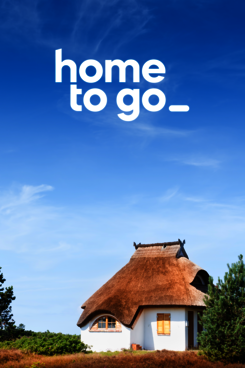 Reetgedecktes Haus vor blauem Himmel